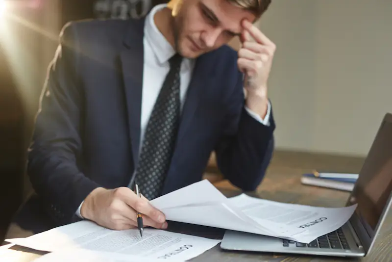 stressed-businessman-working-with-contract-documents cálculo rescisão