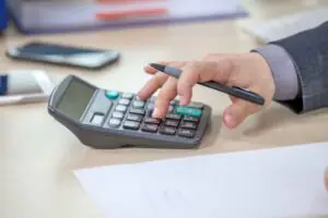 homem usando calculadora para calcular hora extra