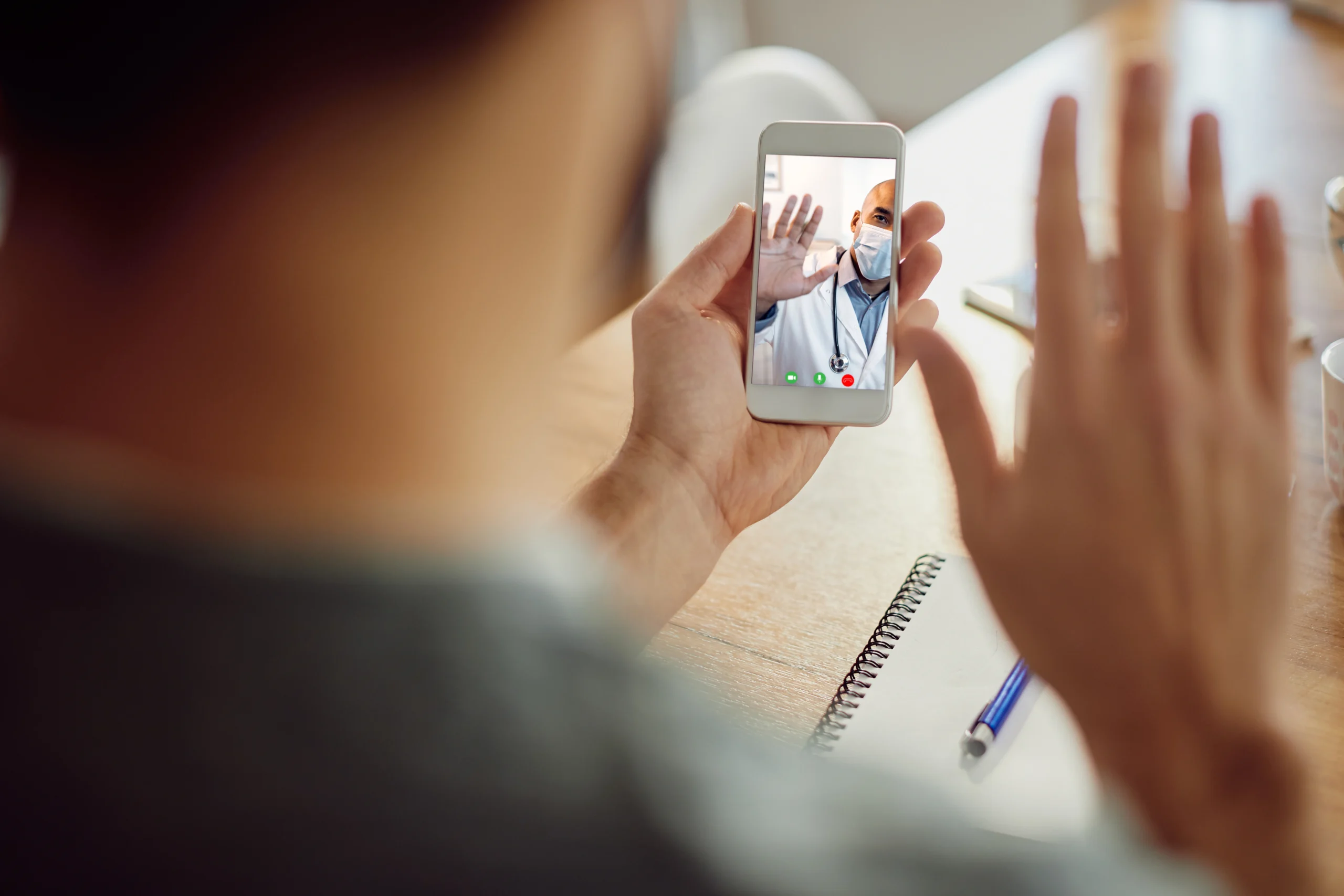 closeup african american doctor greeting his patient video call mobile phone scaled closeup african american doctor greeting his patient video call mobile phone scaled