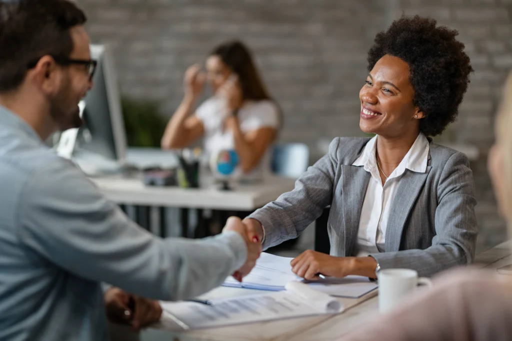happy african american bank manager shaking hands with client after successful agreement office 1 happy african american bank manager shaking hands with client after successful agreement office 1