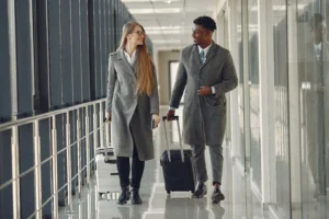homem negro elegante no aeroporto com sua parceira de negocios em viagens corporativas