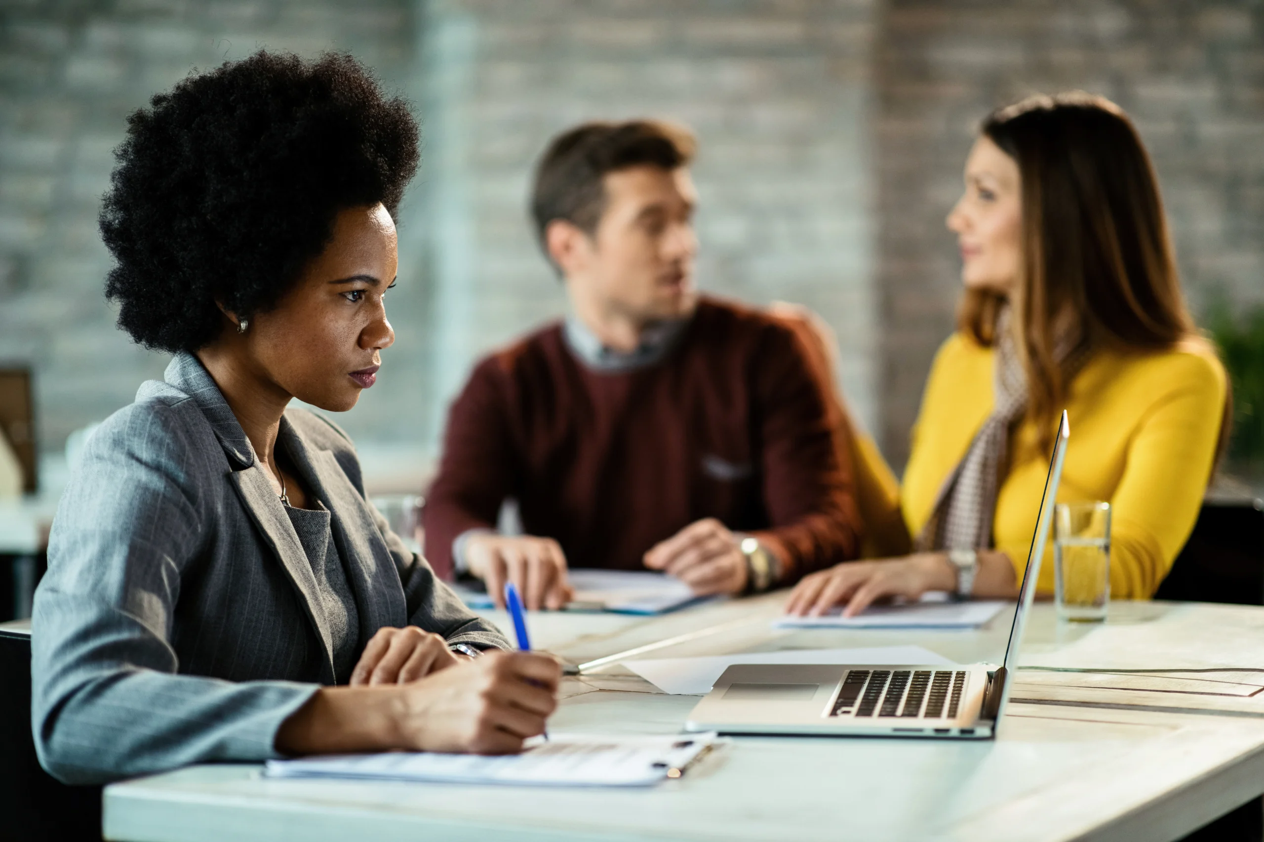 black female bank manager using laptop writing notes while having meeting with couple office scaled black female bank manager using laptop writing notes while having meeting with couple office scaled