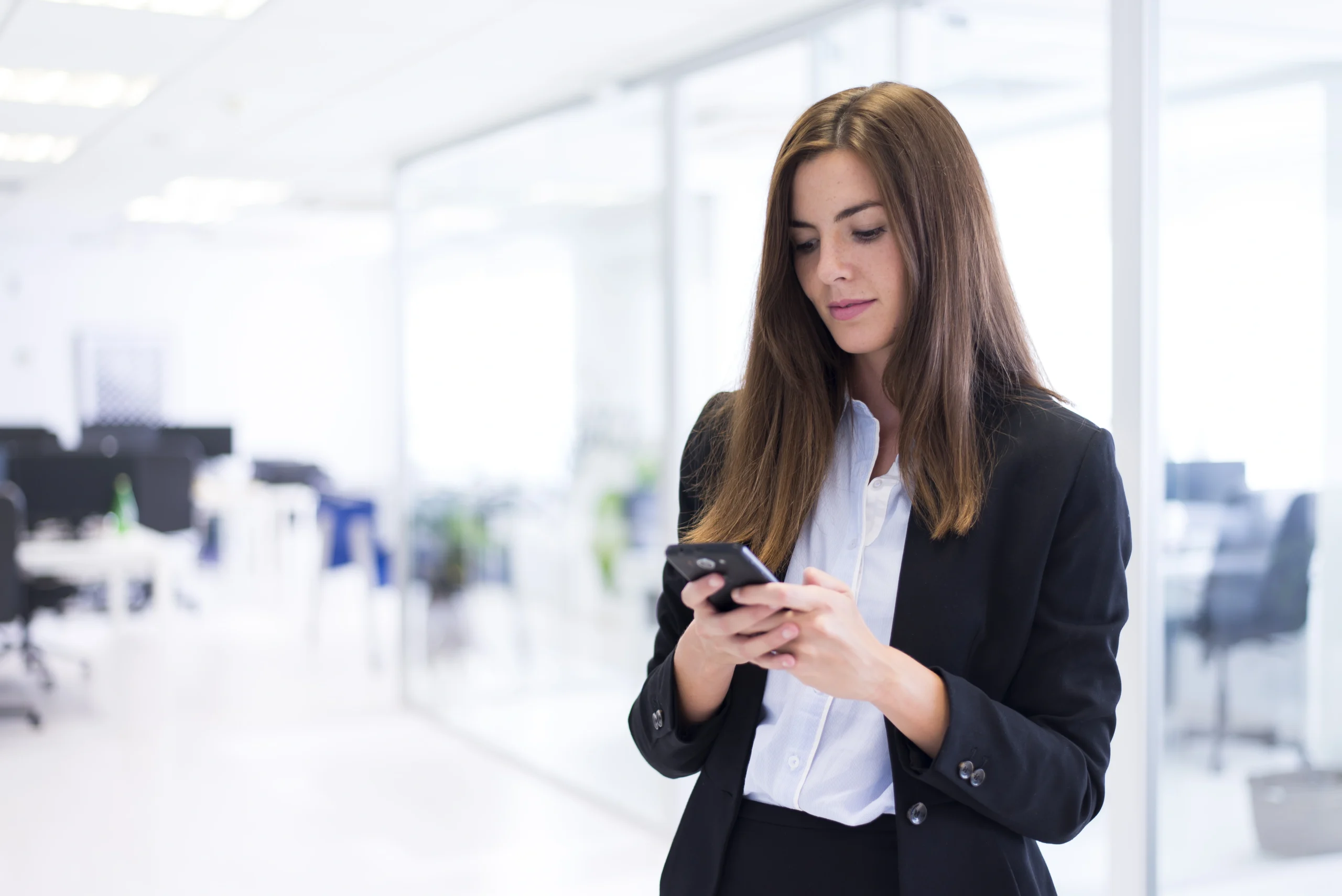 Celular corporativo pode ser monitorado? Regras e leis trabalhistas mulher que datilografa em seu telefone scaled