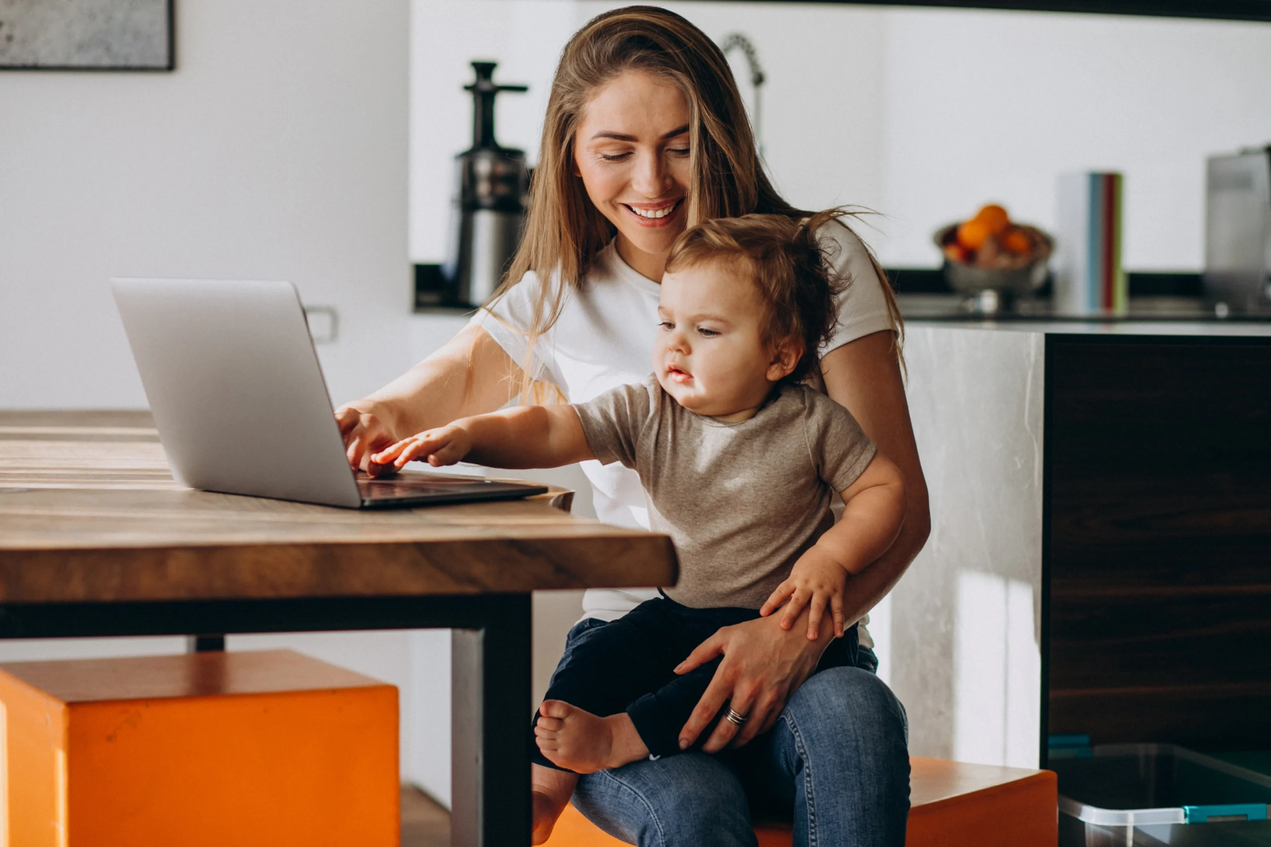 young mother working from home laptop with her little son scaled young mother working from home laptop with her little son scaled