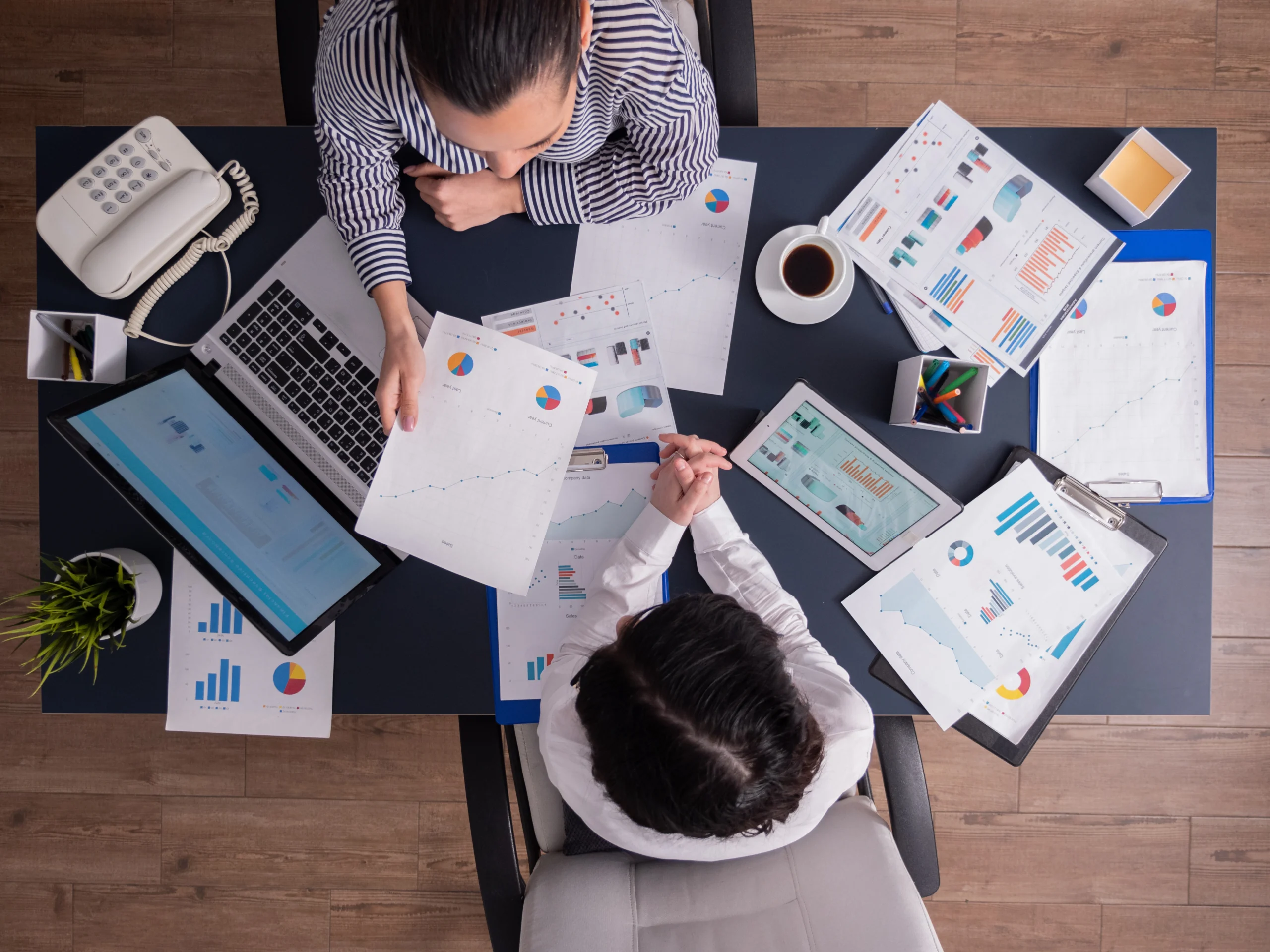 vista superior de funcionarios de escritorio reunidos analisando graficos financeiros segurando prancheta scaled vista superior de funcionarios de escritorio reunidos analisando graficos financeiros segurando prancheta scaled