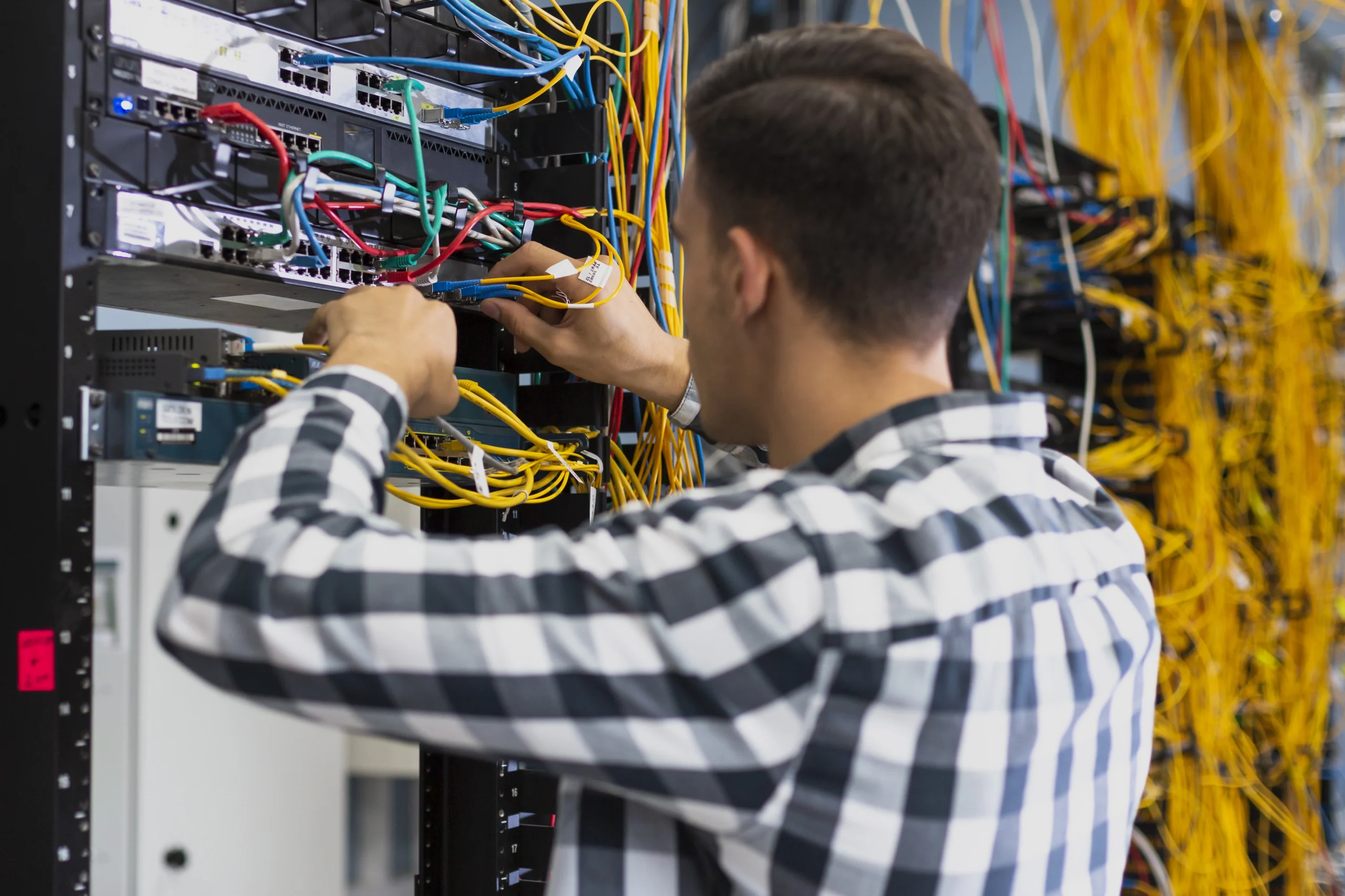 young man working ethernet switch scaled young man working ethernet switch scaled