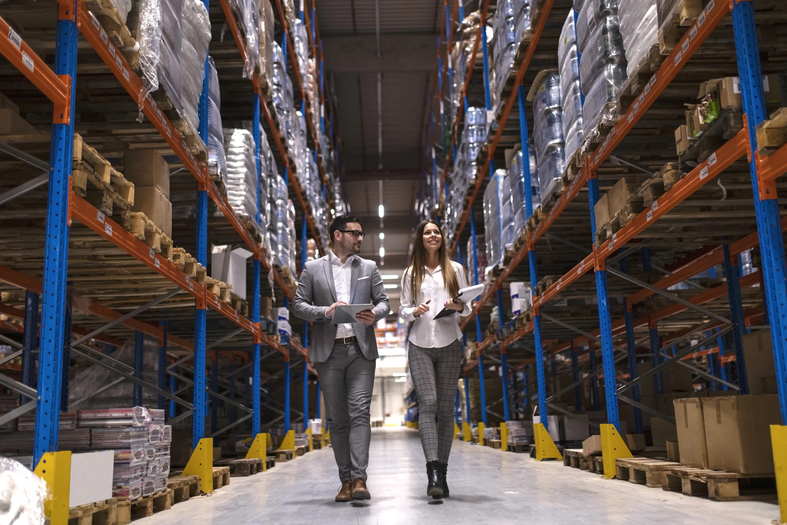 warehouse managers walking through large distribution center scaled warehouse managers walking through large distribution center scaled