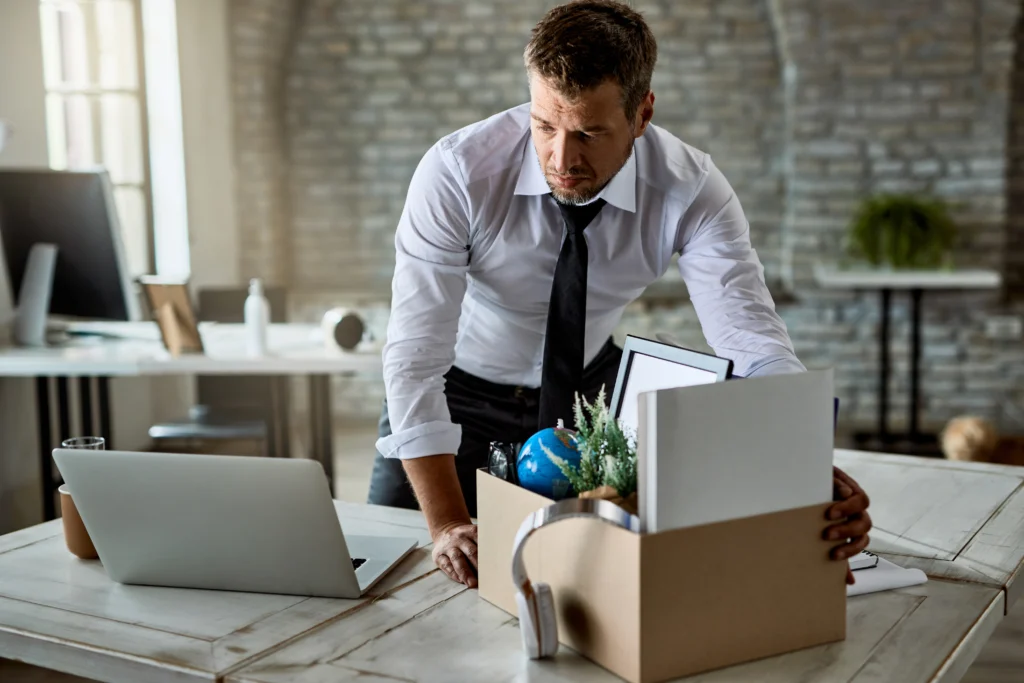 sad entrepreneur packing his belongings cardboard box while leaving office after losing his job sad entrepreneur packing his belongings cardboard box while leaving office after losing his job