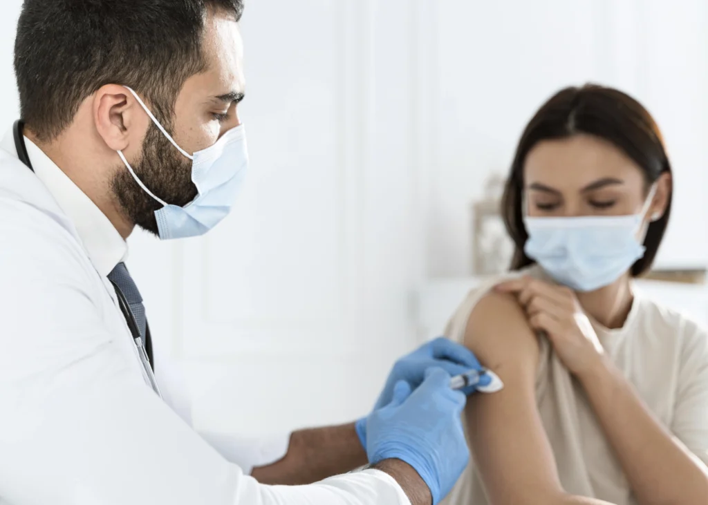 doctor vaccinating young woman doctor vaccinating young woman