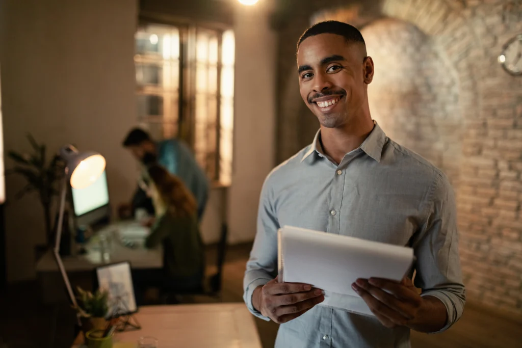 portrait happy black entrepreneur working late business reports looking camera office portrait happy black entrepreneur working late business reports looking camera office