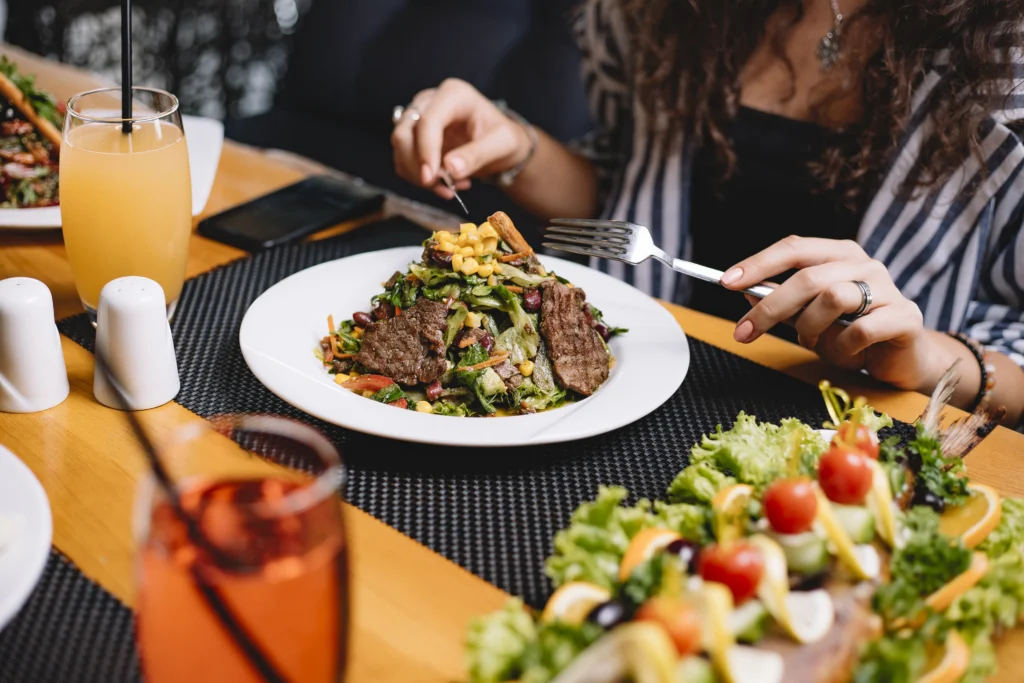 side view woman eating beef meat salad with vegetables corns side view woman eating beef meat salad with vegetables corns