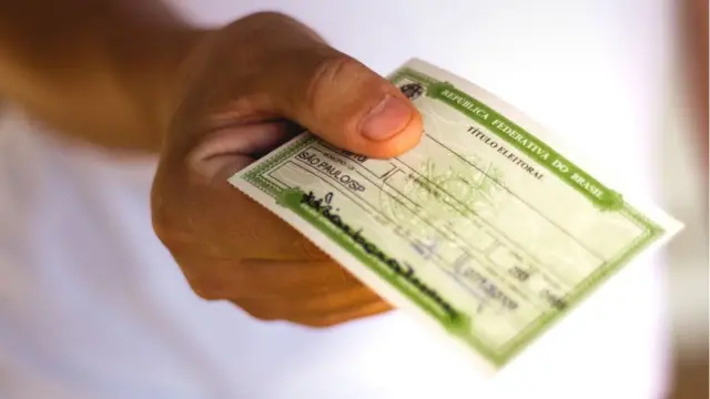 mesário recebendo o título de eleitor de cidadão durante o atendimento eleitoral mesário recebendo o título de eleitor de cidadão durante o atendimento eleitoral