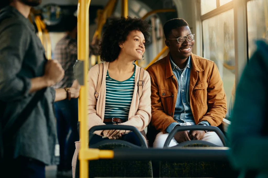 happy black couple looking through window while commuting by bus happy black couple looking through window while commuting by bus