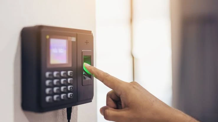 Funcionário registrando o ponto no relógio FUNCIONÁRIO REGISTRANDO O PONTO NO RELÓGIO